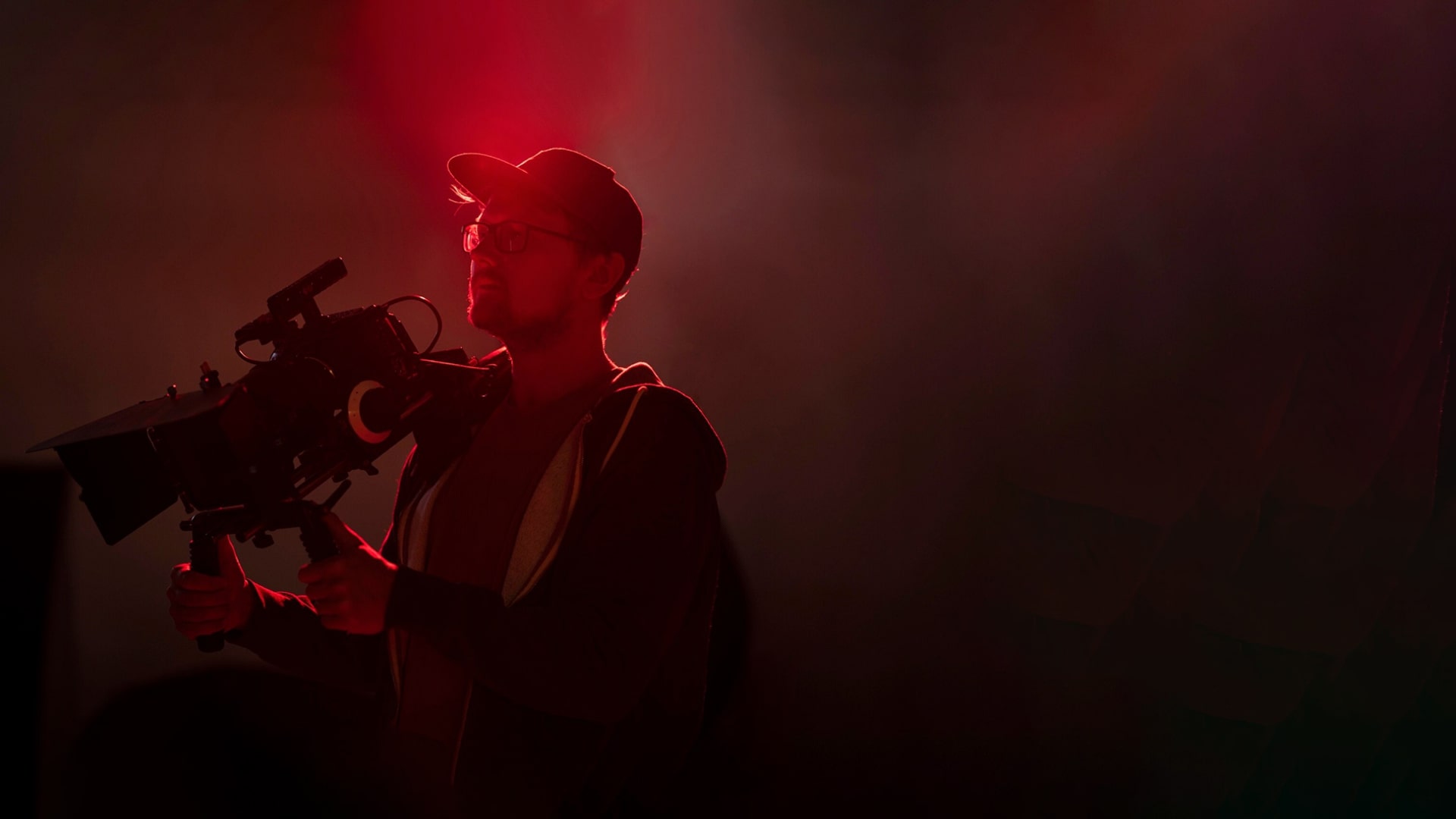 Aspiring film maker holding a camera in cinematic lighting - showcase talent on Keep It Short.